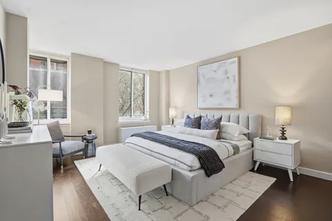 a spacious bedroom with a bed and wooden floor