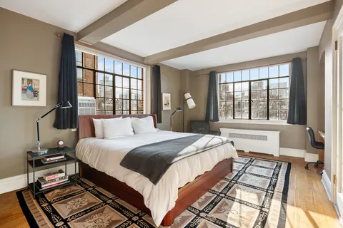 a bedroom with a bed and a large window