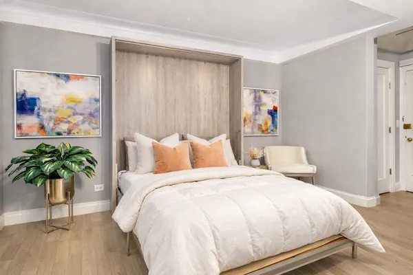 a spacious bedroom with bed and a painting on the wall