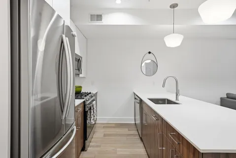 a kitchen with stainless steel appliances granite countertop a refrigerator a oven and a sink