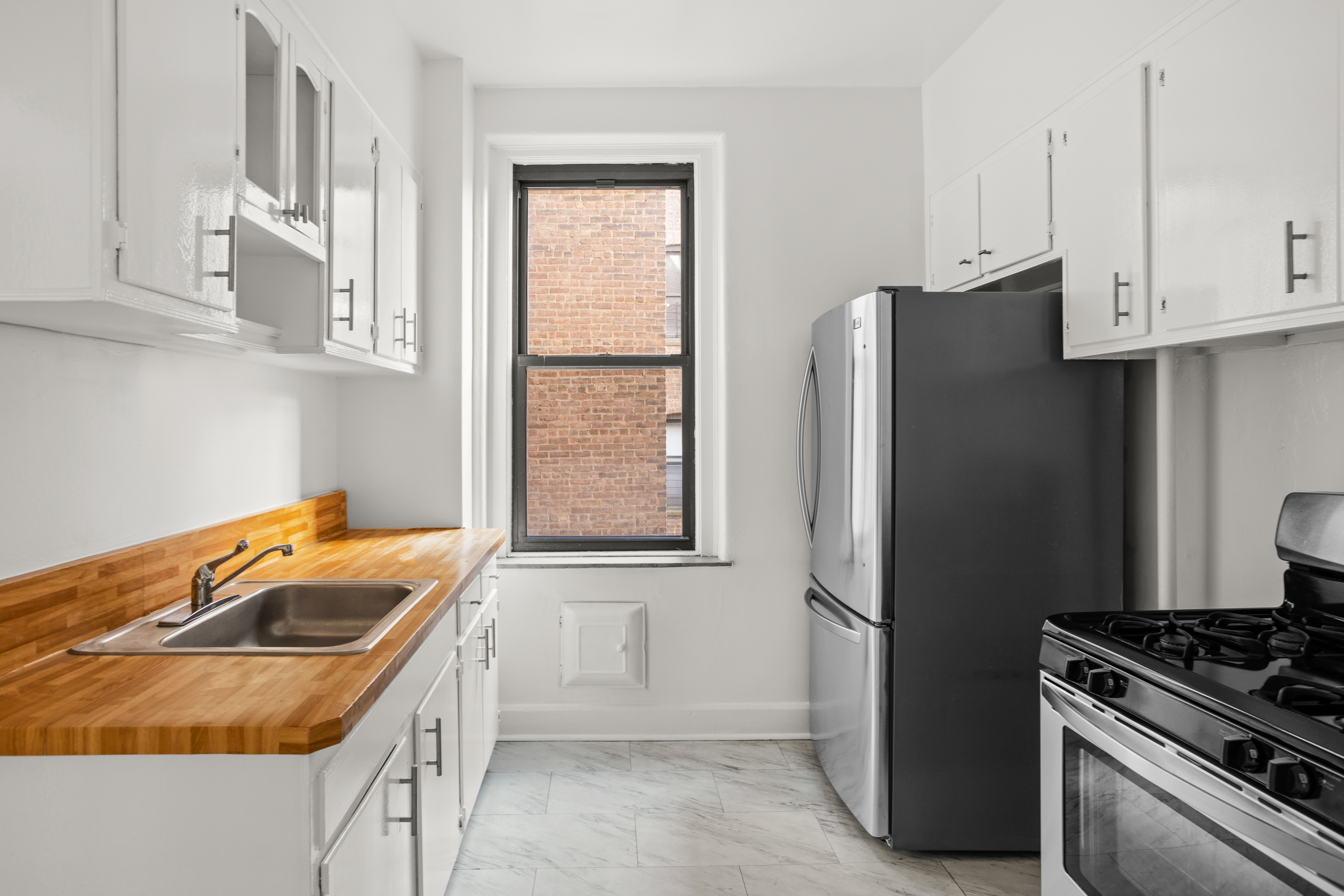 35-30 82nd Street, Unit 32 Queens, NY 11372 - Photo 3 of 11 a kitchen that has a sink and a stove