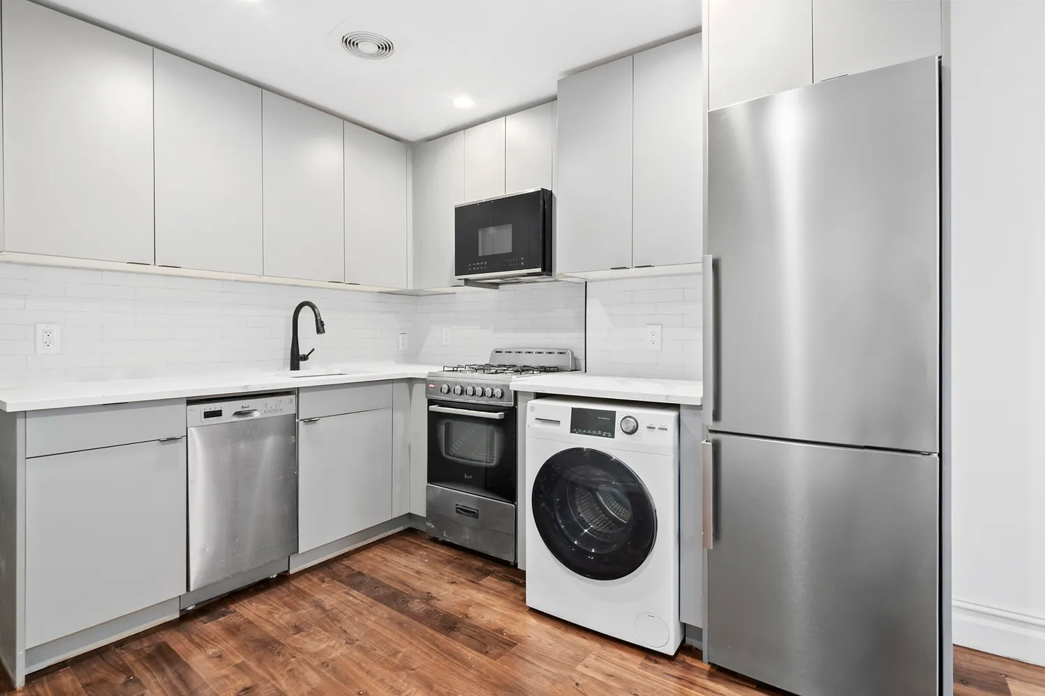 a kitchen with a sink and a washer dryer