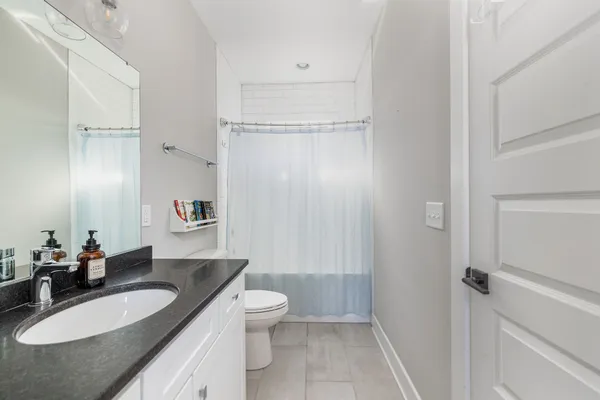 a bathroom with a granite countertop sink a toilet and a mirror