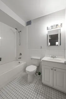 a bathroom with a sink a toilet a mirror and bathtub