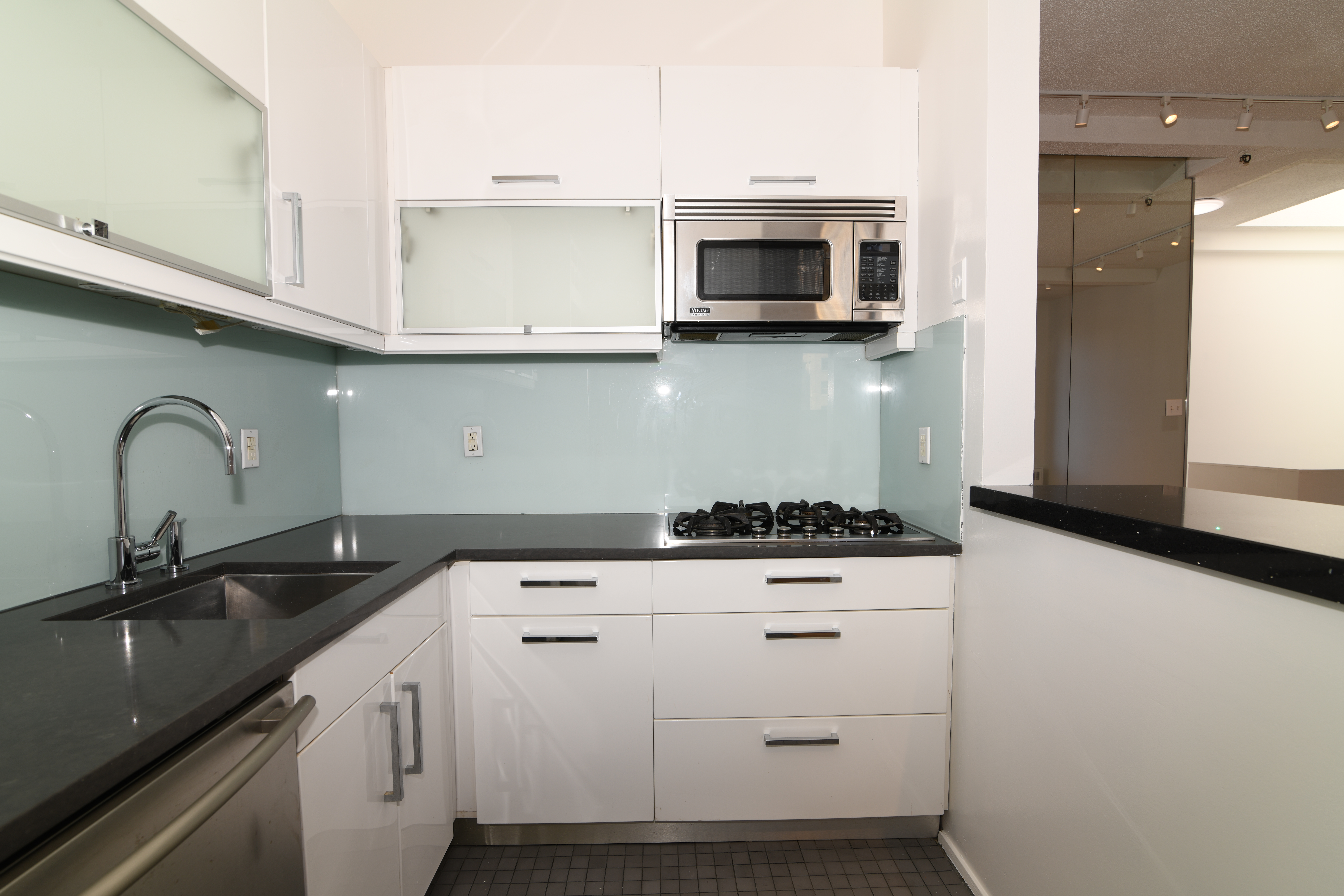 303 Mercer Street, Unit A601 Manhattan, NY 10003 - Photo 5 of 19 a kitchen with granite countertop white cabinets and appliances