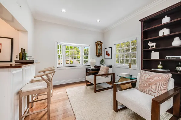 a living room with furniture a bookshelf and a window