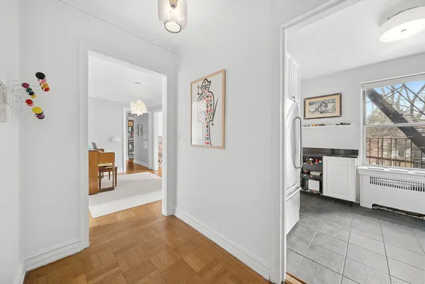 a view of a hallway that has a dining table and chairs