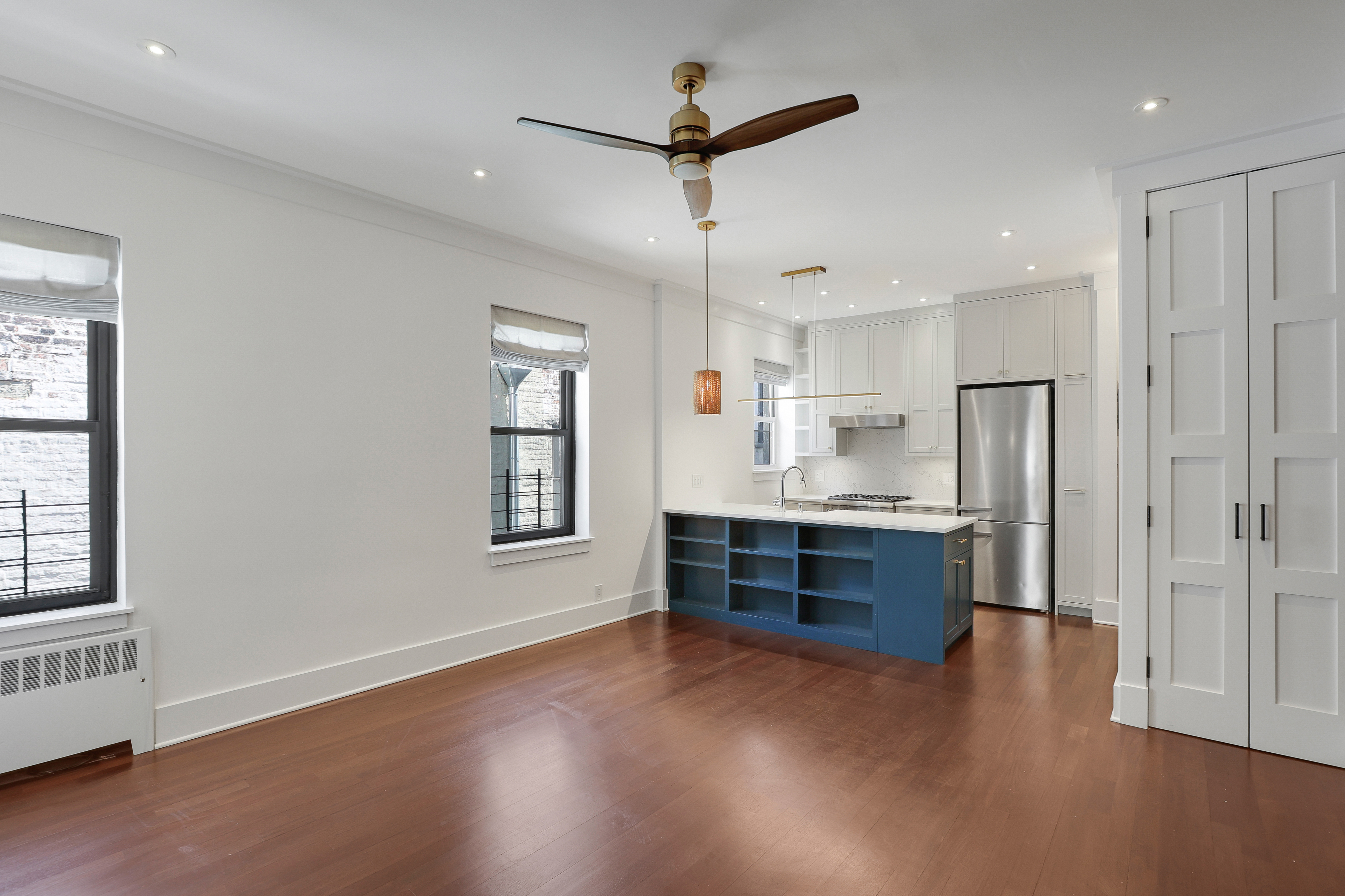 133 East 30th Street, Unit PH5B Manhattan, NY 10016 - Photo 17 of 24 a kitchen with stainless steel appliances granite countertop a refrigerator a sink dishwasher a stove and white countertops with wooden floor