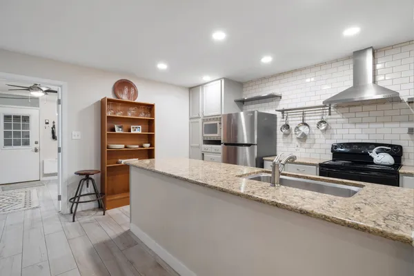a kitchen with stainless steel appliances granite countertop a stove and a sink