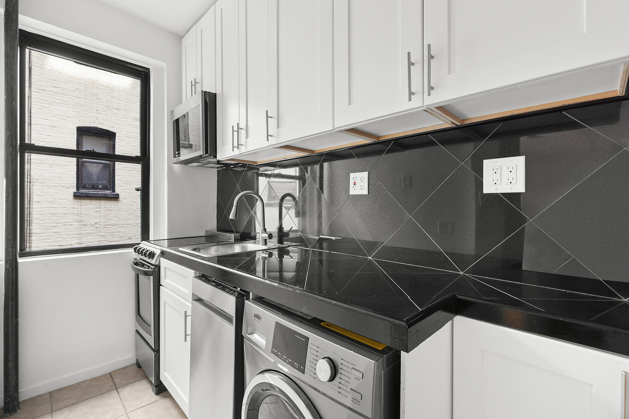 205 West 10th Street, Unit 3D Manhattan, NY 10014 - Photo 3 of 7 a kitchen with stainless steel appliances a sink and cabinets