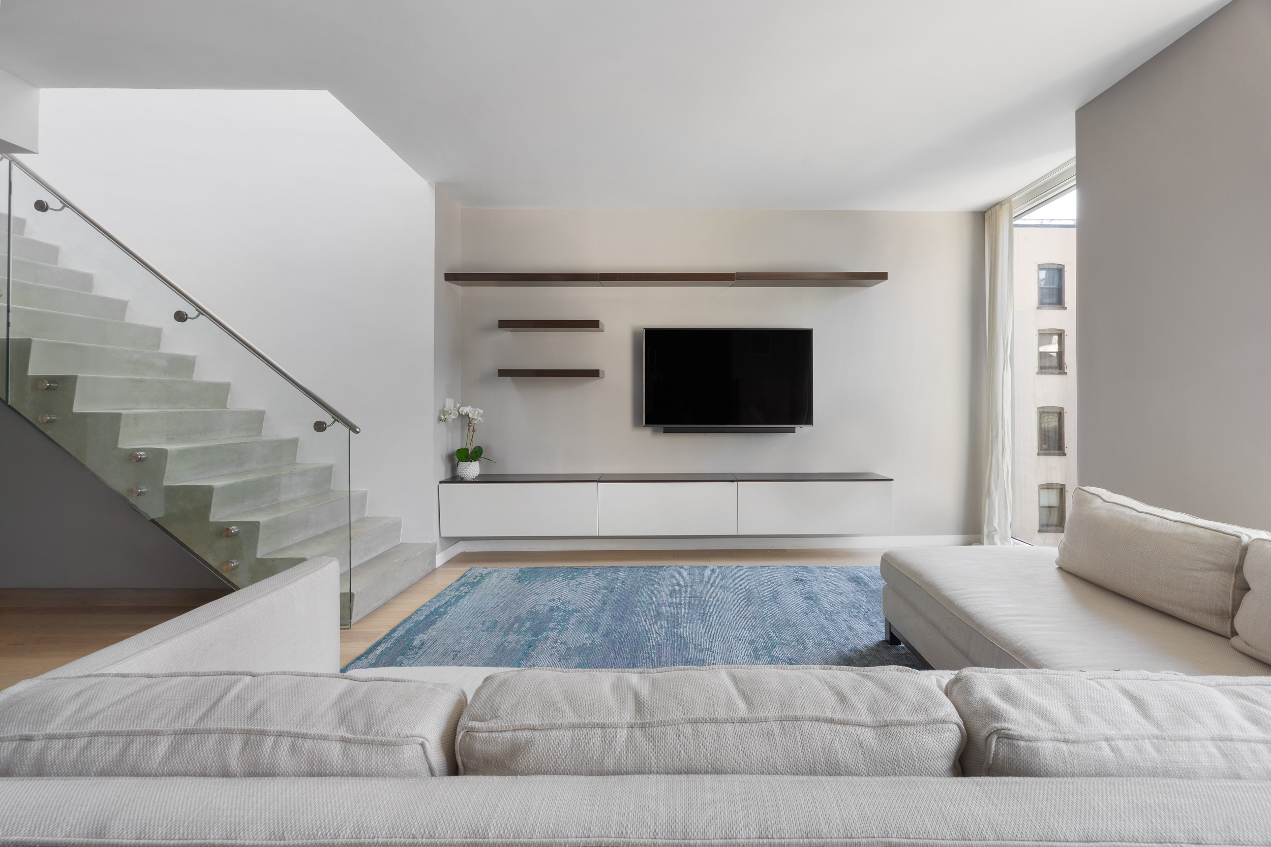 540 West 49th Street, Unit PH1N Manhattan, NY 10019 - Photo 2 of 18 a living room with a couch and a flat screen tv