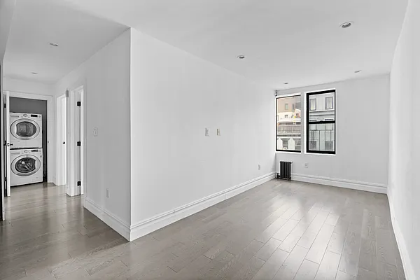 20 Avenue A, Unit 3AB Manhattan, NY 10009 - Photo 2 of 13 an empty room with wooden floor and windows