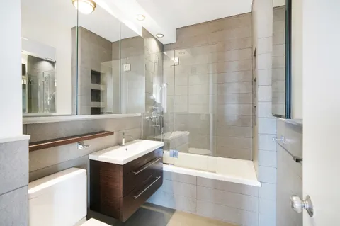 a bathroom with a bathtub sink and mirror