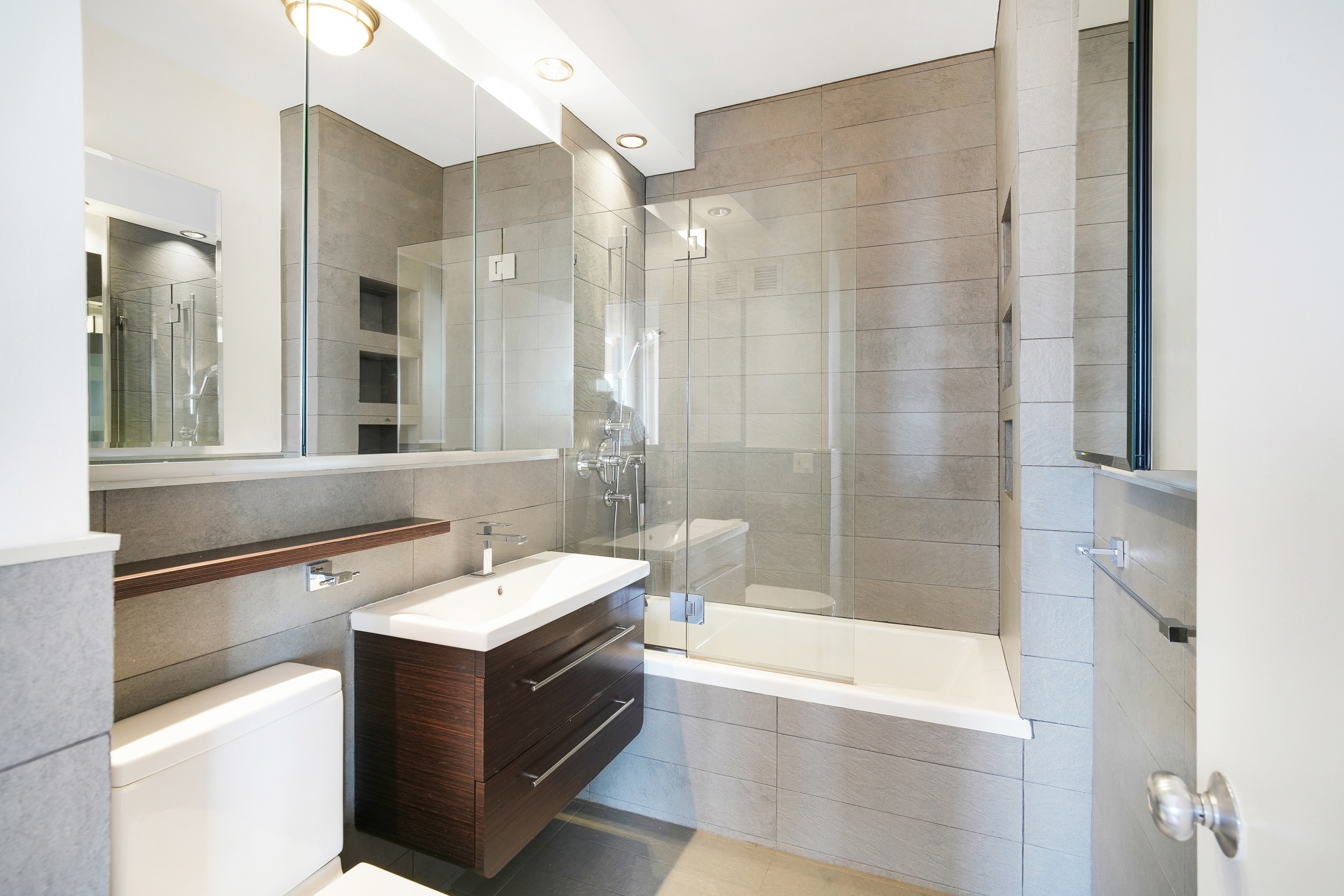 360 East 88th Street, Unit 34A Manhattan, NY 10128 - Photo 12 of 35 a bathroom with a bathtub sink and mirror
