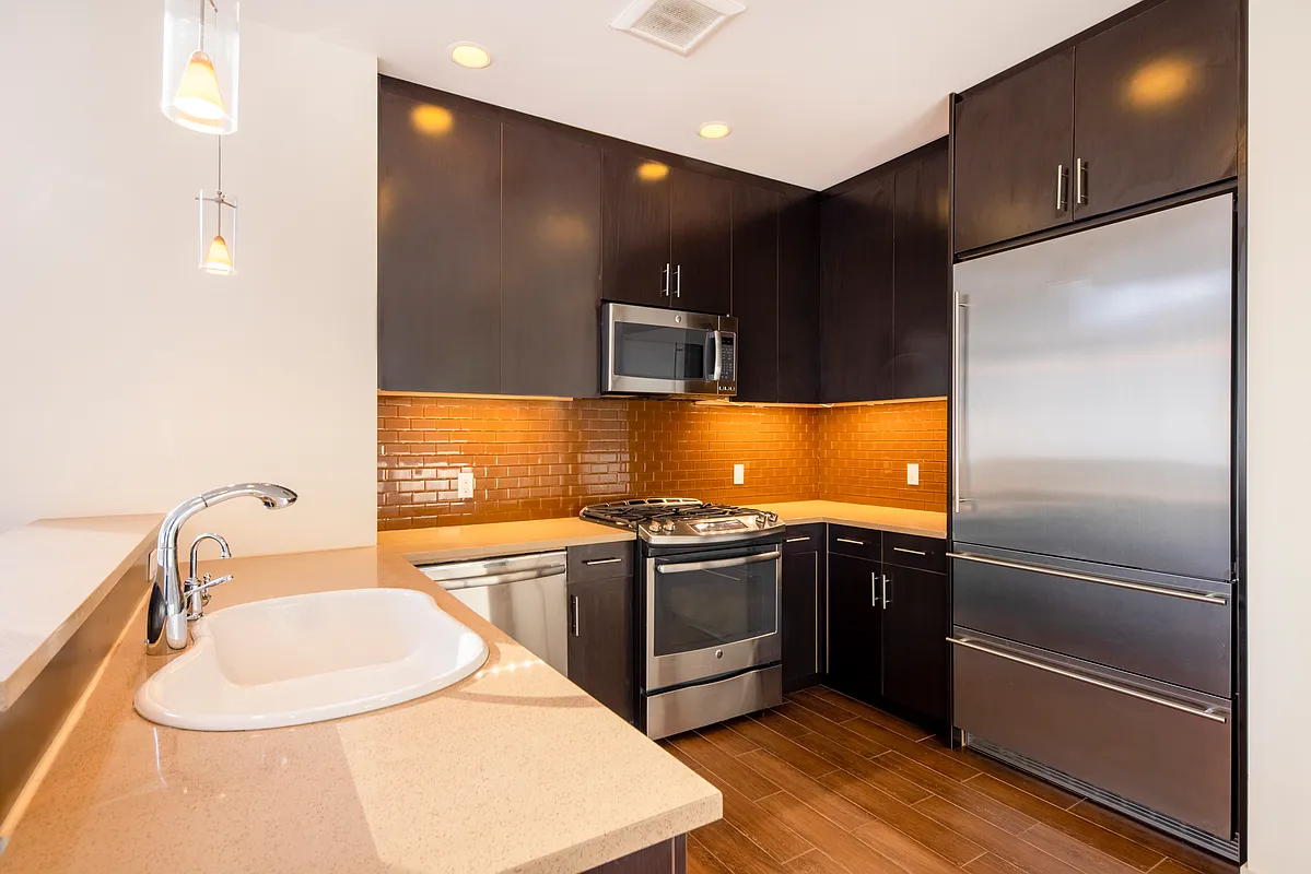 51-42 27th Street, Unit 6C Queens, NY 11101 - Photo 3 of 10 a kitchen with stainless steel appliances granite countertop a refrigerator and a sink