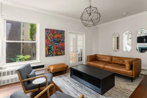 a living room with furniture a rug and a window