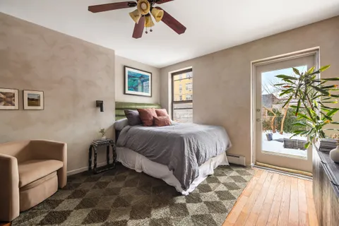 a bedroom with a bed lamp and a large window