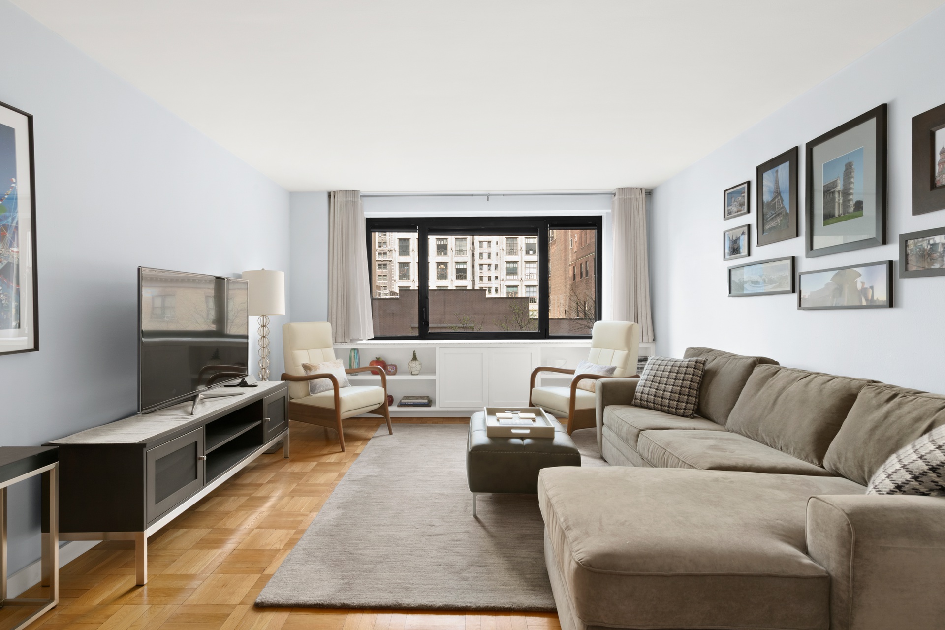 10 West 66th Street, Unit 7C Manhattan, NY 10023 - Photo 1 of 19 a living room with furniture and a flat screen tv