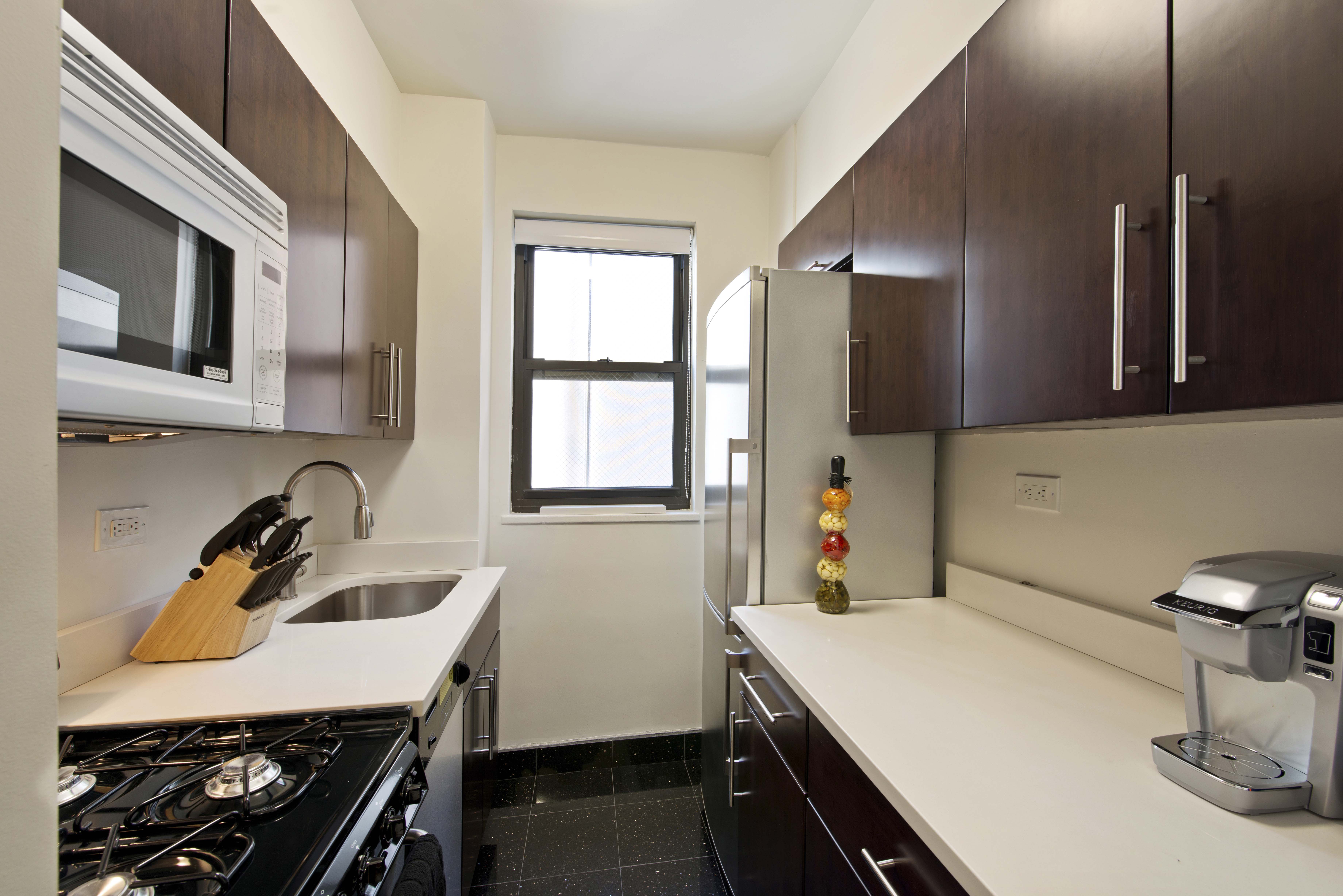 30 East 37th Street, Unit 6C Manhattan, NY 10016 - Photo 2 of 5 a room with a sink a window and gym equipment