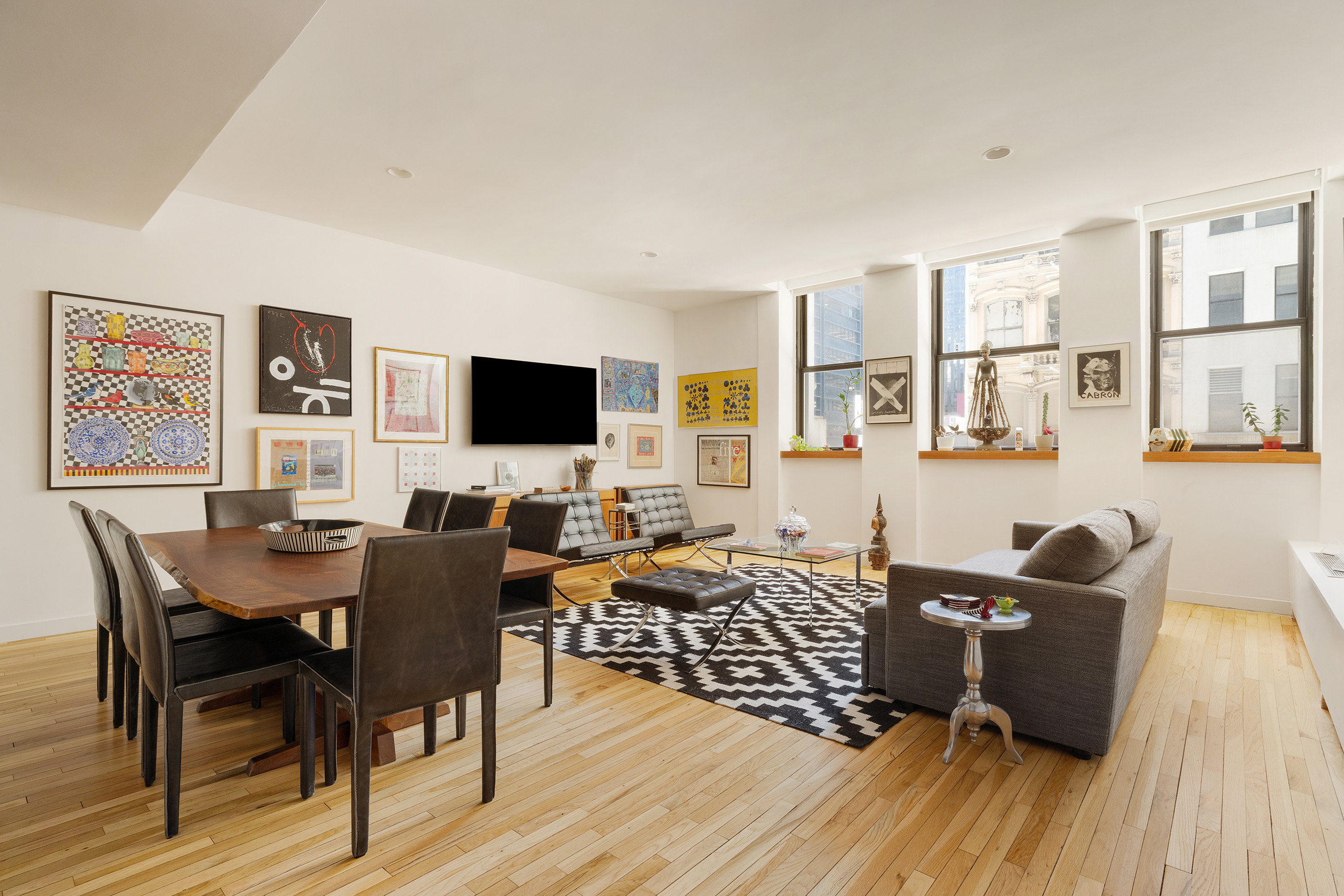176 Broadway, Unit 3C Manhattan, NY 10038 - Photo 1 of 8 a living room with furniture and a flat screen tv