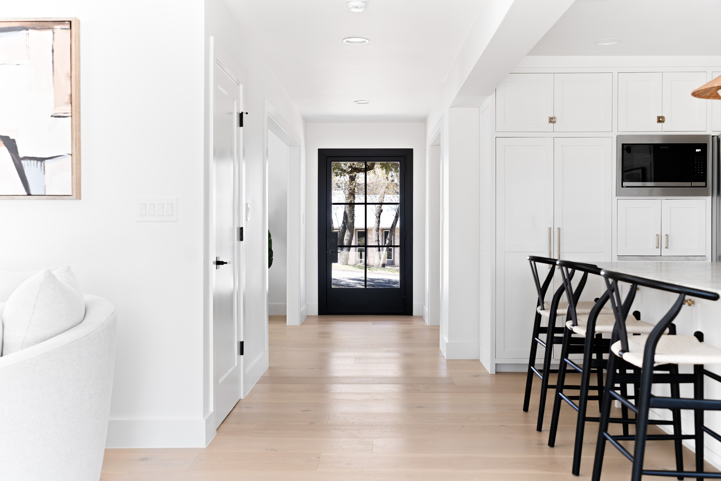 1317 Thaddeus Cove Austin, TX 78746 - Photo 2 of 22 a hallway with wooden floor and windows