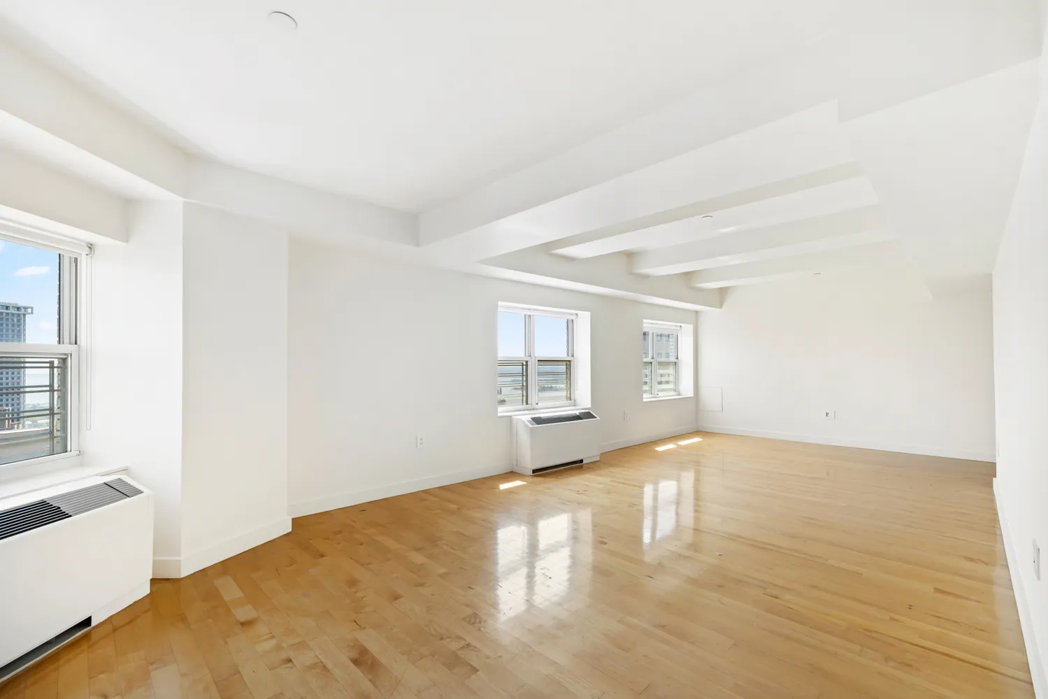 a view of a room with wooden floor and a window