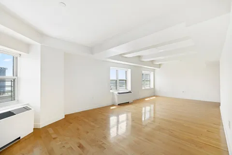 a view of a room with wooden floor and a window