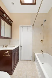 a bathroom with a tub sink and mirror