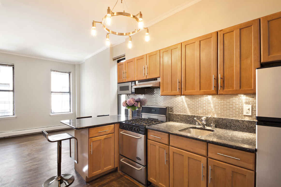 442 Amsterdam Avenue, Unit 4C Manhattan, NY 10024 - Photo 4 of 9 a kitchen with stainless steel appliances granite countertop a sink a stove cabinets counter space and a window