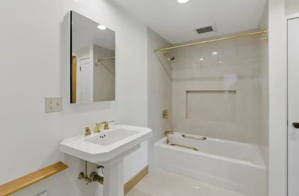 a bathroom with a bath tub a mirror and a sink