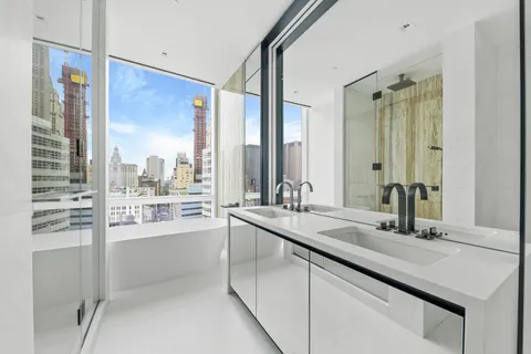 a bathroom with a white toilet sitting next to a bathroom sink and a shower