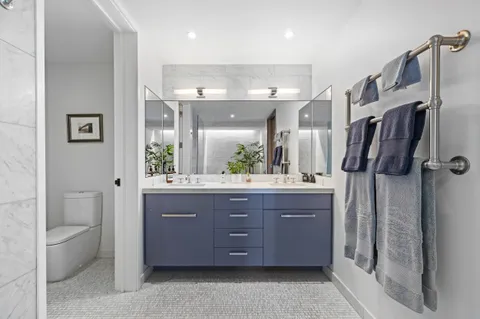 a bathroom with a granite countertop sink a toilet a mirror and shower