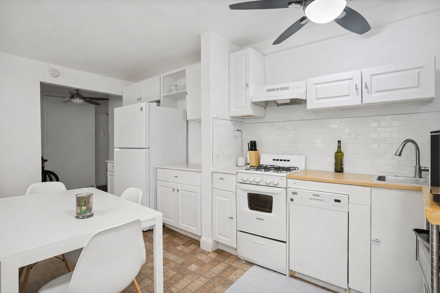 141 East 55th Street, Unit 4C Manhattan, NY 10022 - Photo 2 of 7 a kitchen with white cabinets and white appliances
