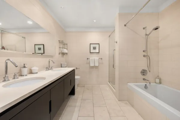 a spacious bathroom with a bathtub sink mirror and shower