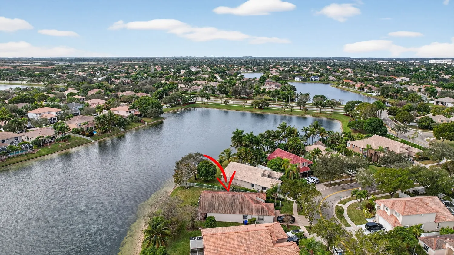 an aerial view of residential houses with outdoor space and lake view