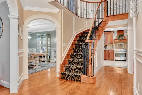 a view of entryway and hall with wooden floor