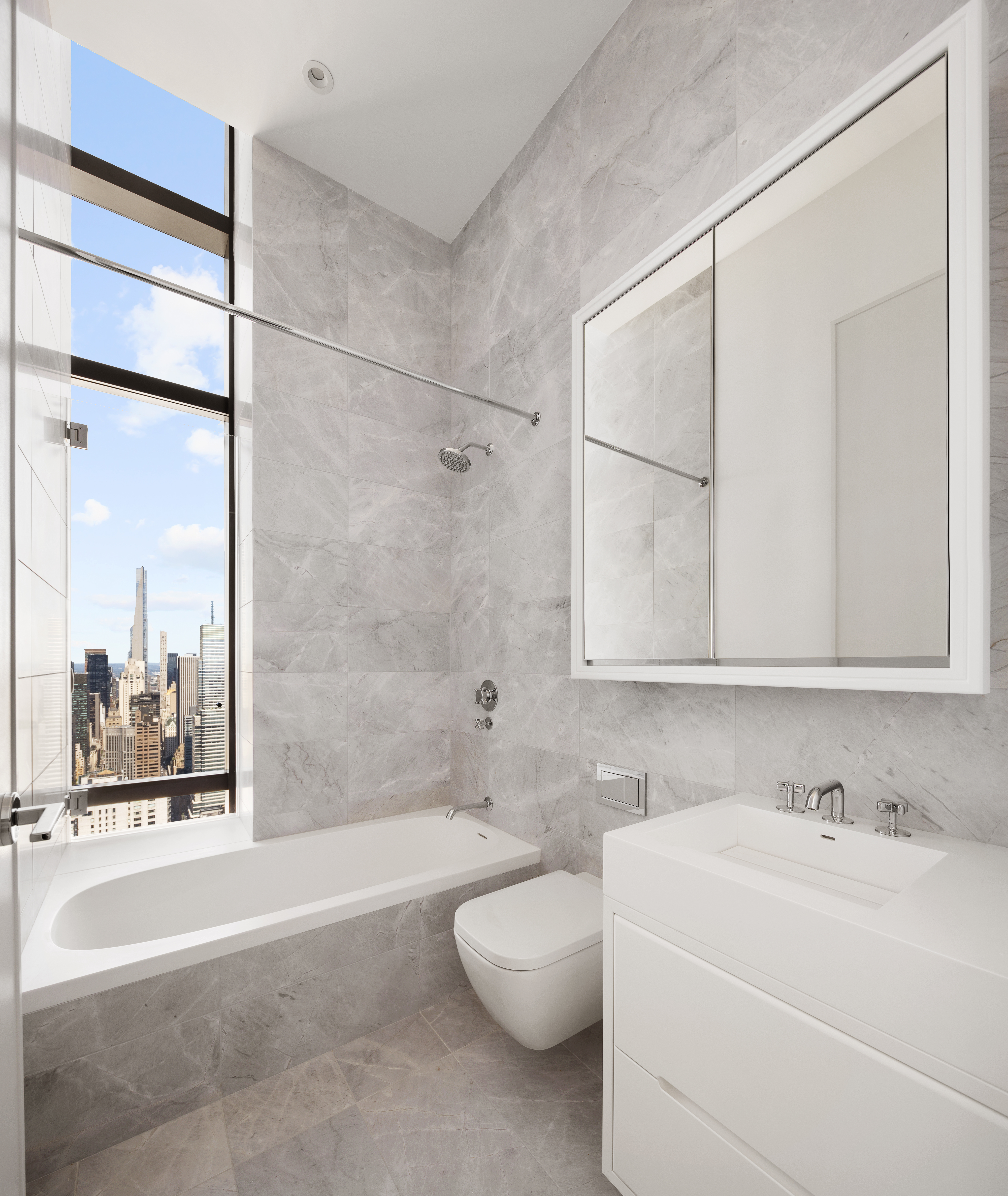 430 East 58th Street, Unit PH71 Manhattan, NY 10022 - Photo 15 of 26 a bathroom with a granite countertop sink mirror toilet and bathtub