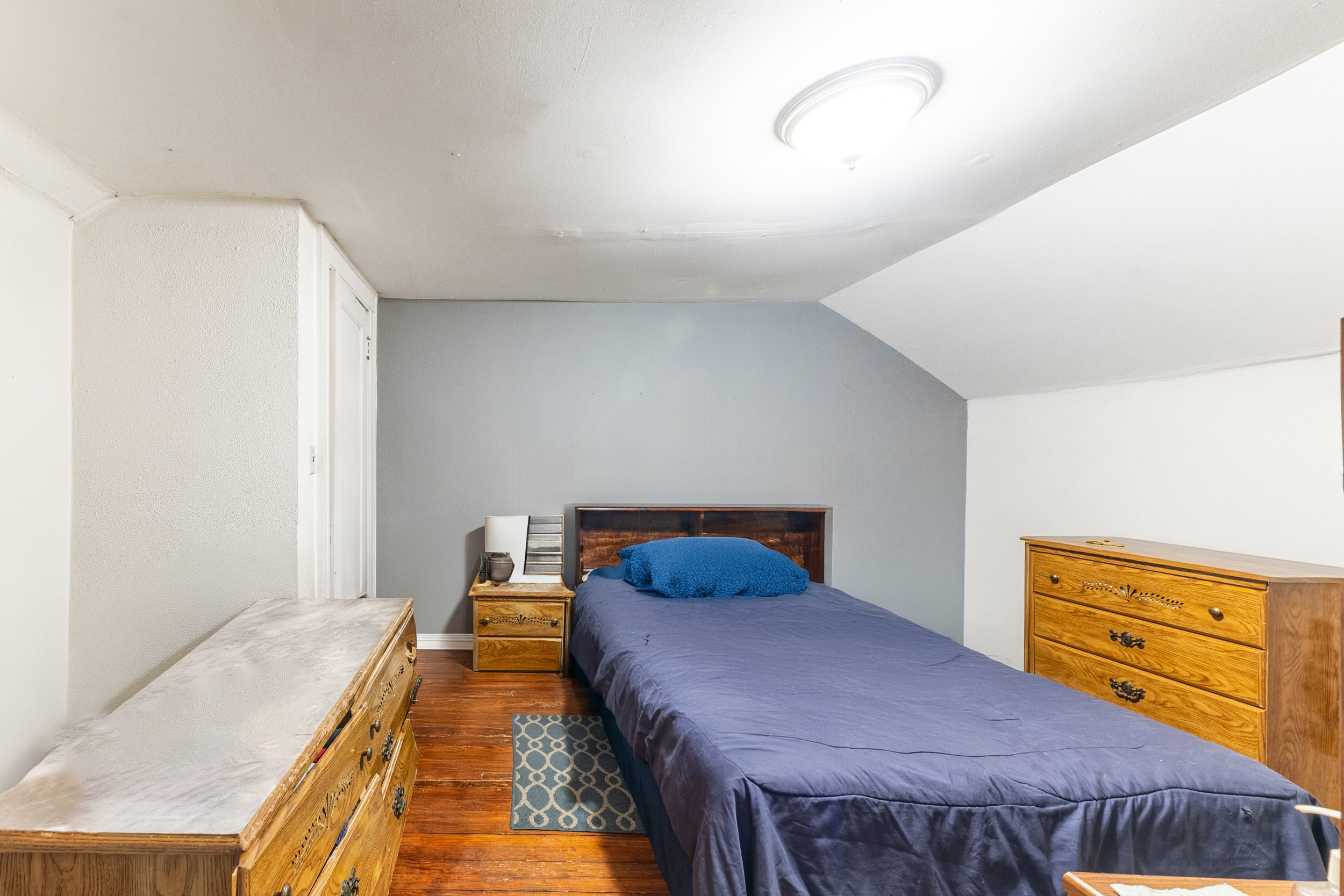 961 East 32nd Street Brooklyn, NY 11210 - Photo 9 of 24 a bedroom with a bed and wooden floor