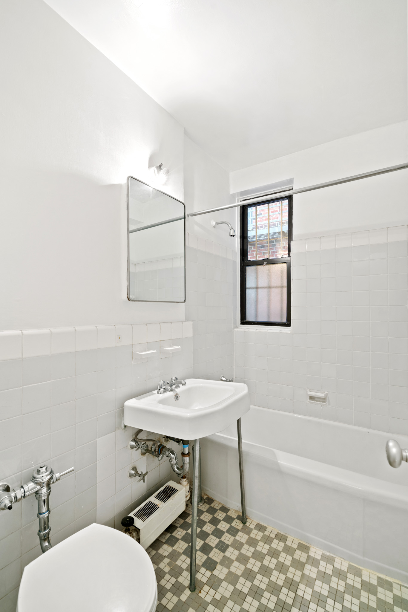60 East 9th Street, Unit 235 Manhattan, NY 10003 - Photo 9 of 14 a bathroom with a toilet a sink and bathtub