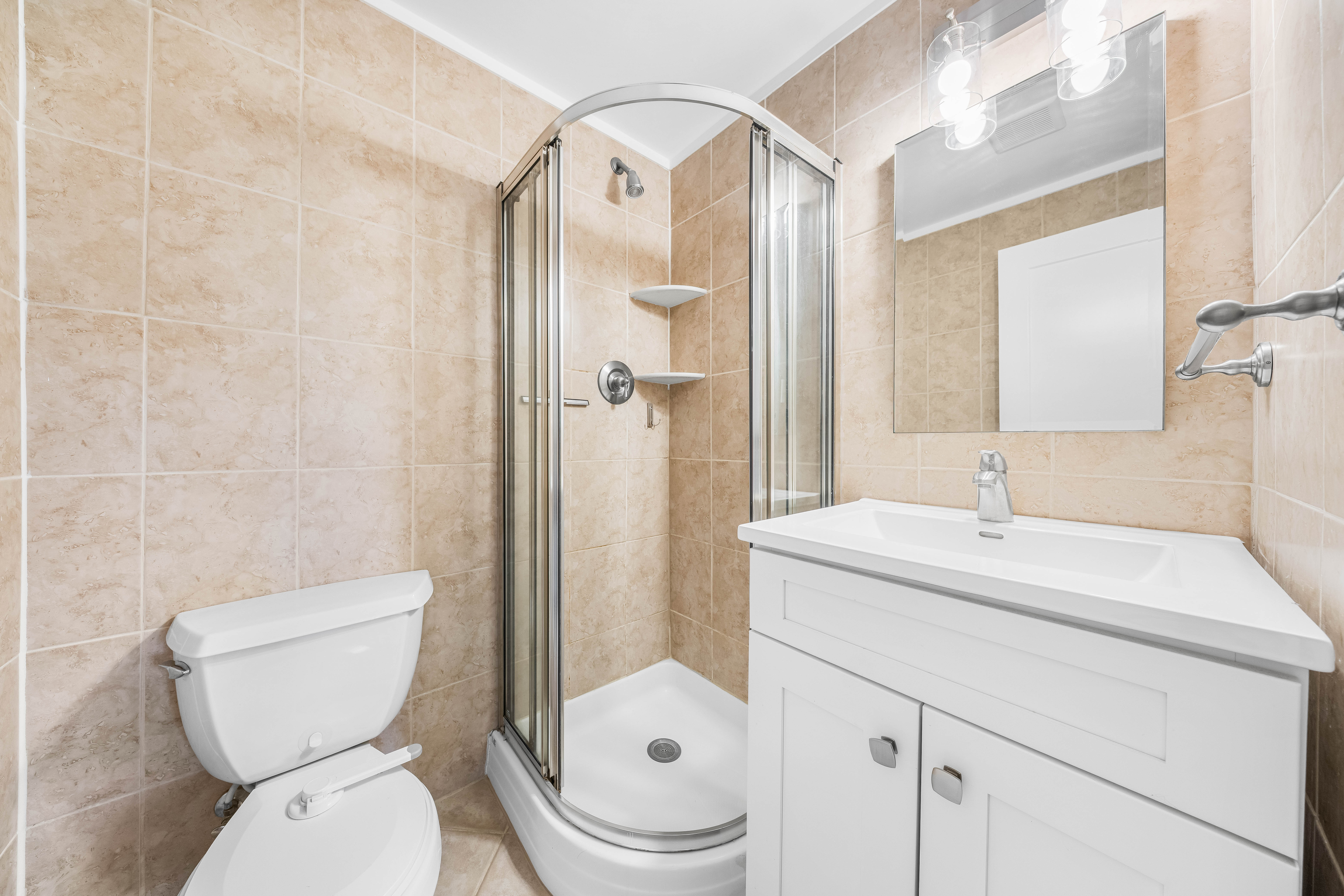 15-80 209th Street, Unit 2 Queens, NY 11360 - Photo 12 of 21 a bathroom with a sink a toilet and shower