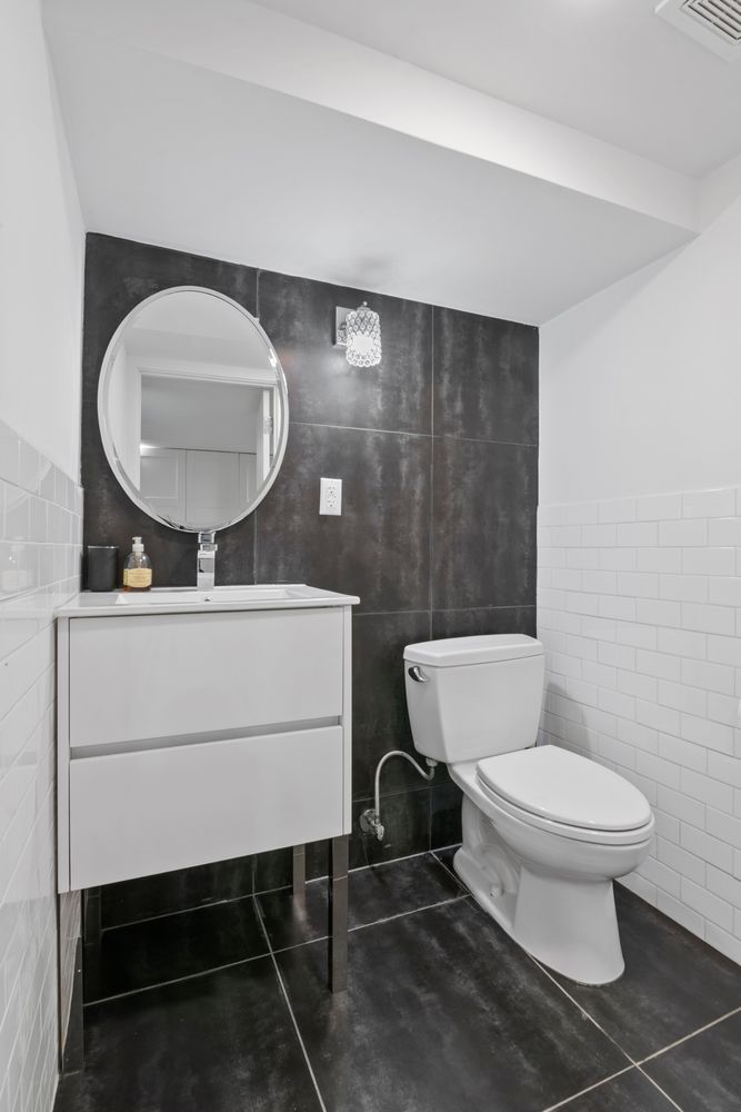 296 Fenimore Street Brooklyn, NY 11225 - Photo 18 of 19 a bathroom with a toilet a sink and a mirror