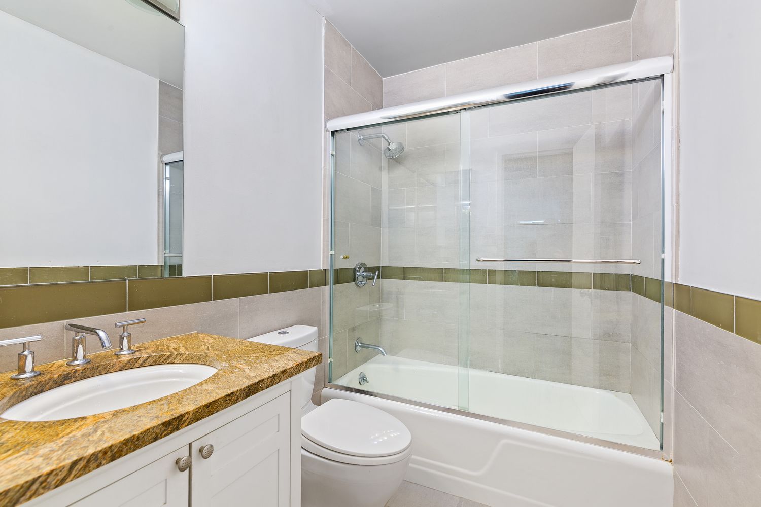 303 East 57th Street, Unit 30E Manhattan, NY 10022 - Photo 5 of 10 a bathroom with a granite countertop bathtub shower sink vanity and toilet