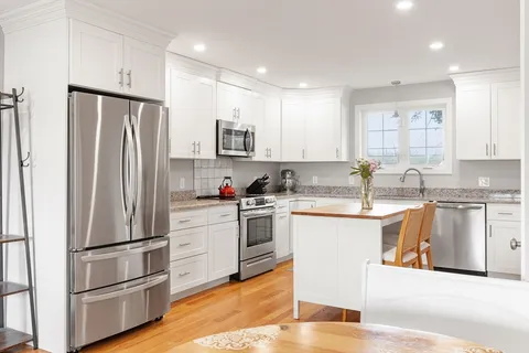 a kitchen with stainless steel appliances granite countertop a refrigerator and a stove top oven