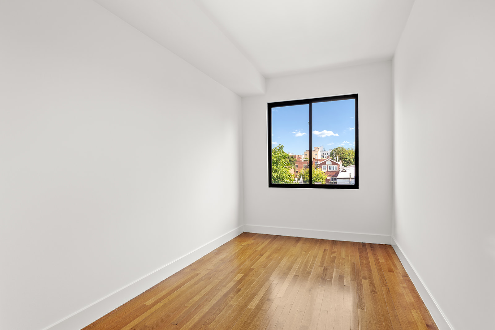 495 Rutland Road, Unit 3 Brooklyn, NY 11203 - Photo 6 of 12 a view of an empty room with wooden floor and a window