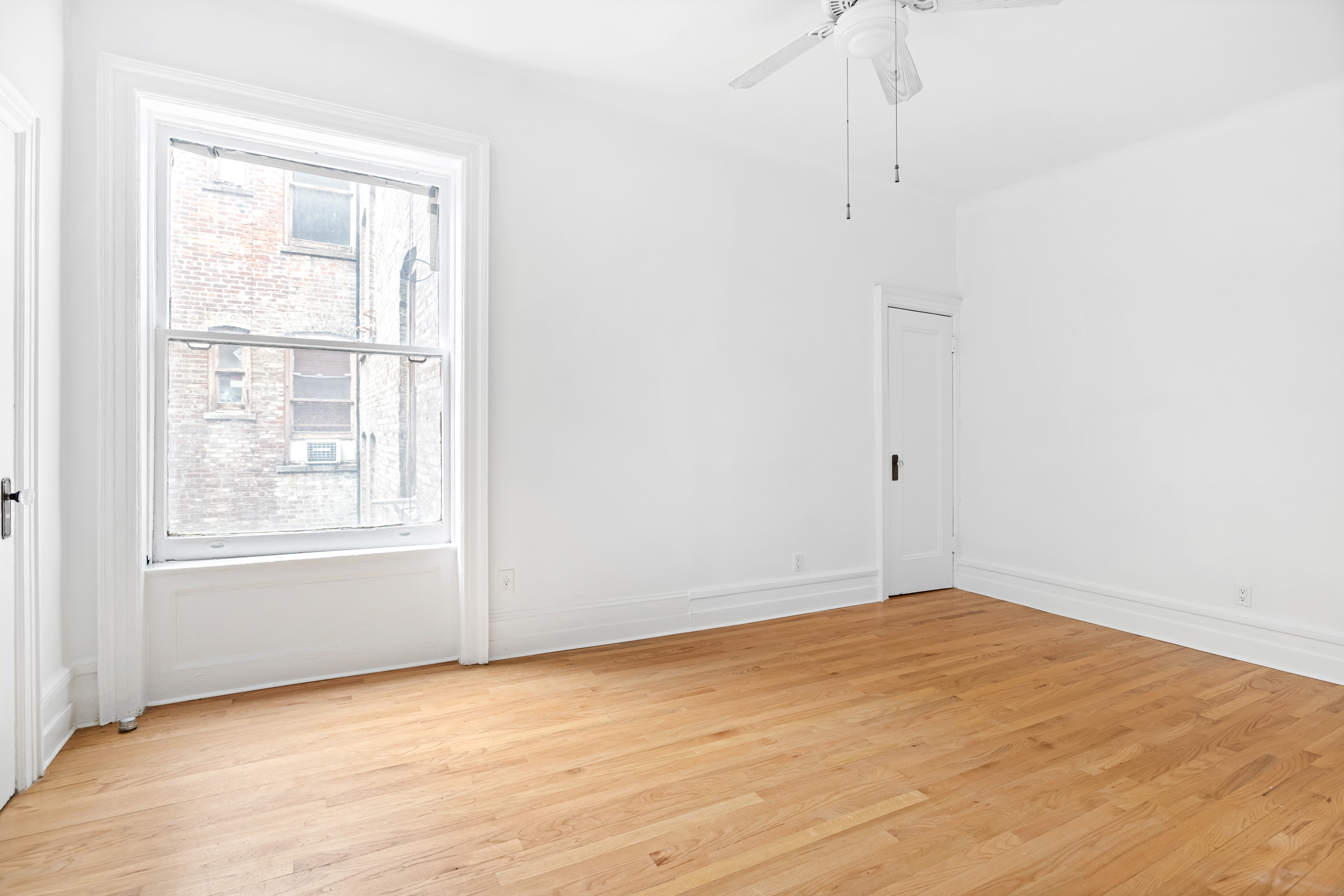 50 East 96th Street, Unit 5D Manhattan, NY 10128 - Photo 5 of 5 an empty room with wooden floor and windows