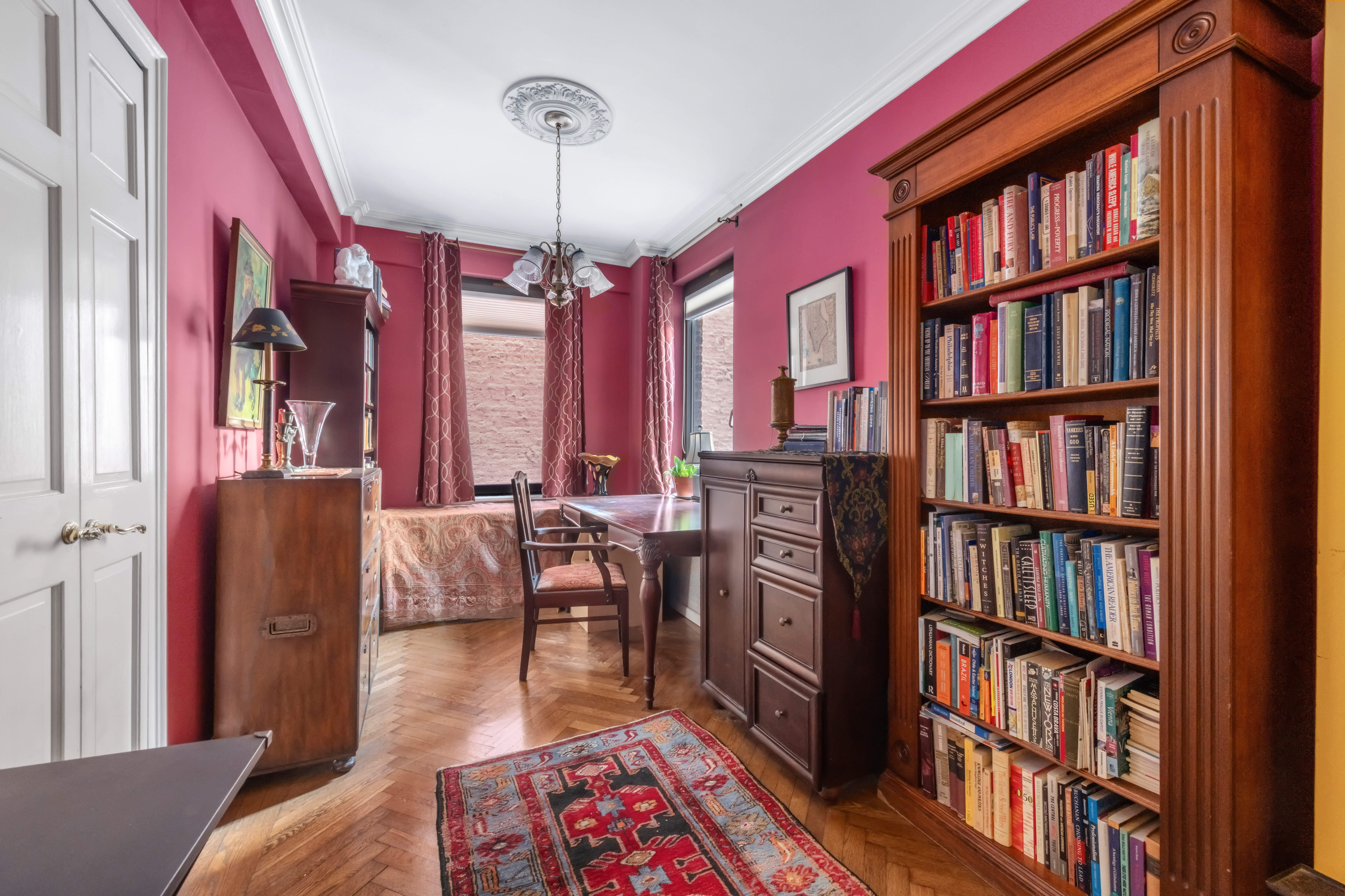 50 Park Avenue, Unit 4C Manhattan, NY 10016 - Photo 5 of 10 a living room with furniture lots of books and a book shelf