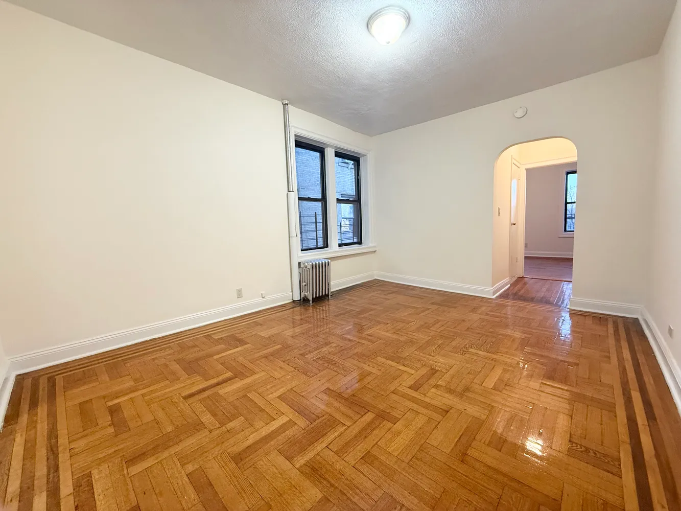 a spacious bedroom with a bed a couch and a window