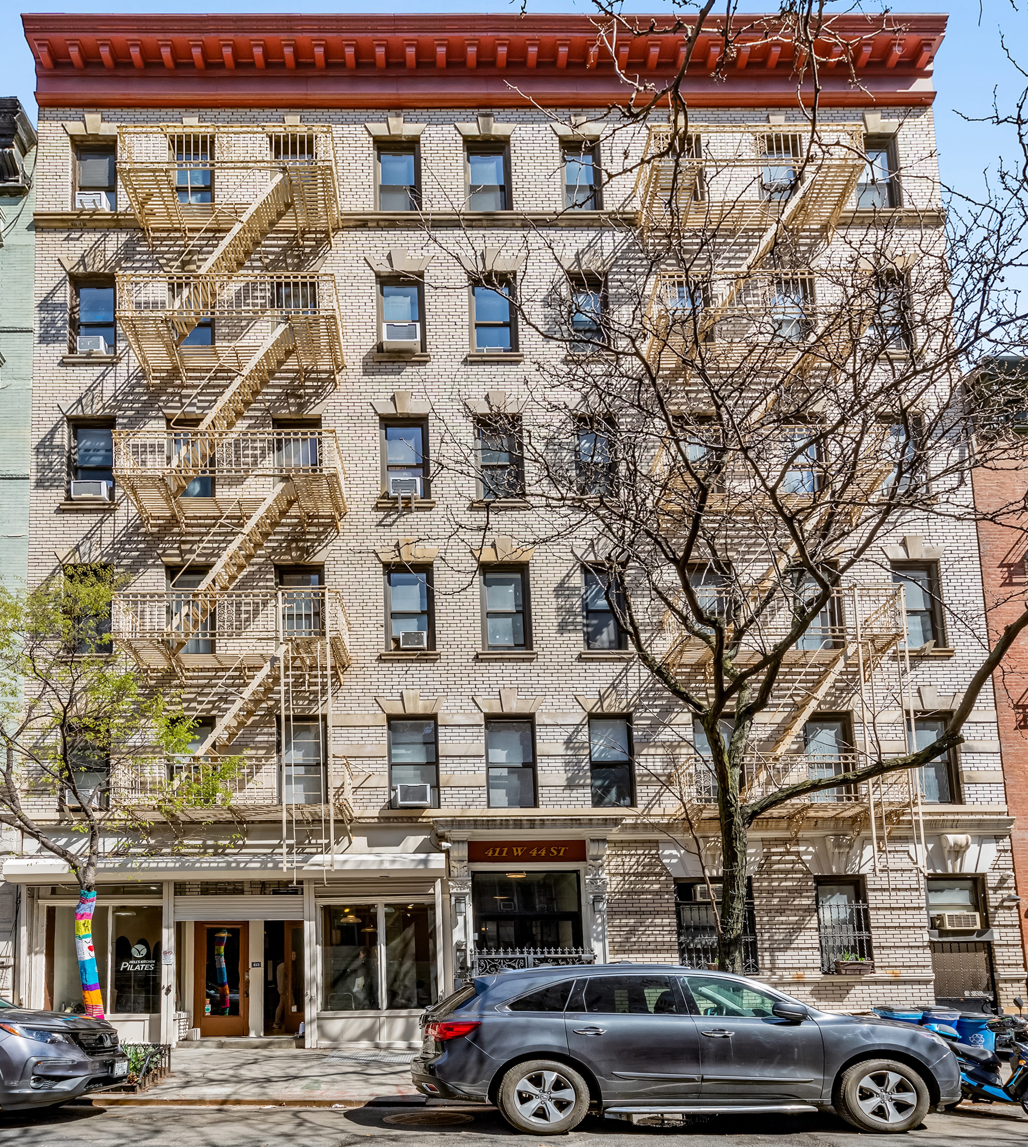 411 West 44th Street, Unit 13 Manhattan, NY 10036 - Photo 7 of 8 a front view of a building with lot of cars parked on the roadside