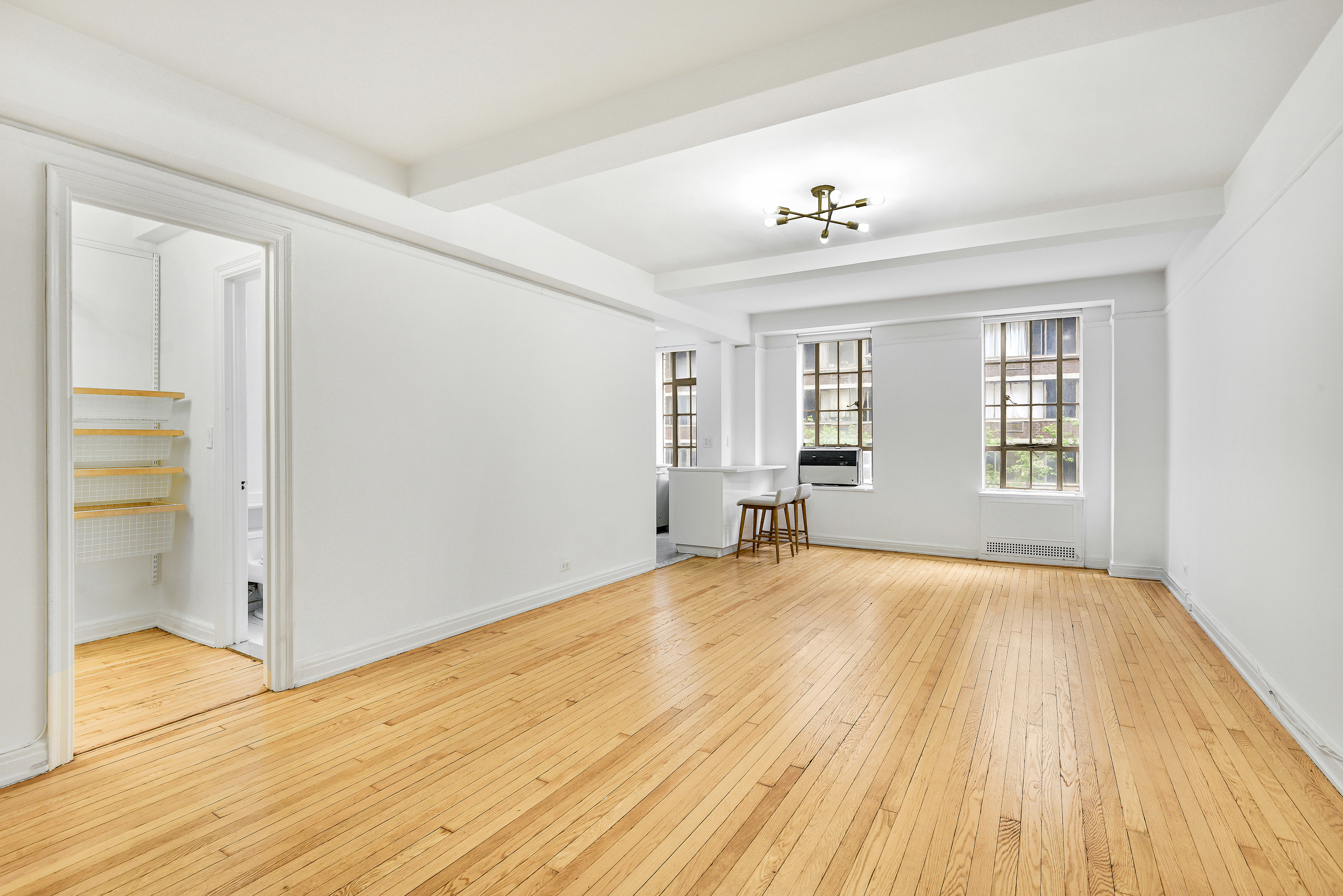 333 West 56th Street, Unit 3H Manhattan, NY 10019 - Photo 3 of 7 wooden floor in an empty room with a window