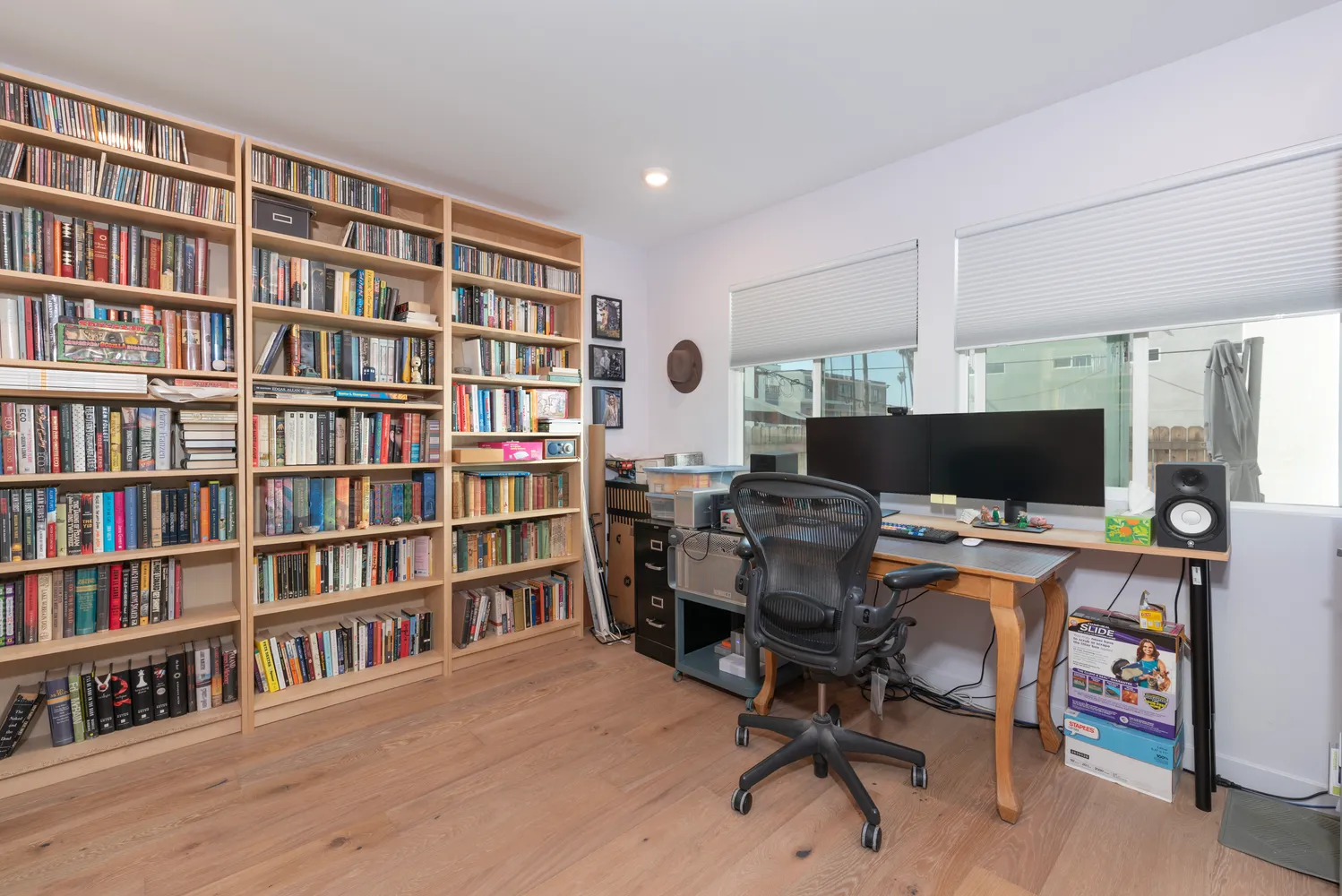 a view of a workspace with furniture and a bookshelf